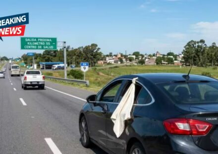 What does it mean to see a white cloth hanging from a car window on the road?